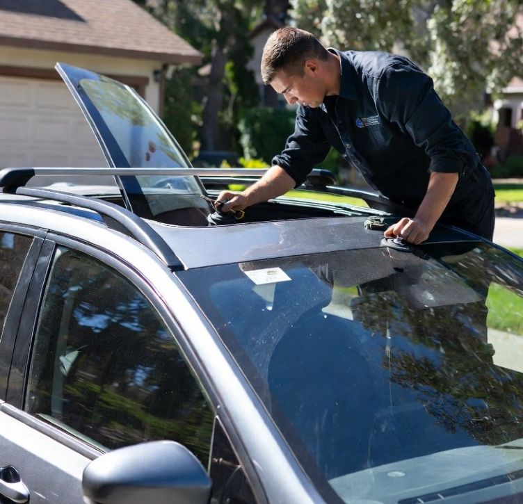 Technician performing a professional mobile auto glass service on a modern SUV